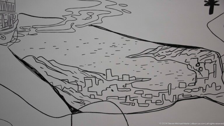 Black line drawing of buildings and mountains on pale surface in Muscat, Oman.