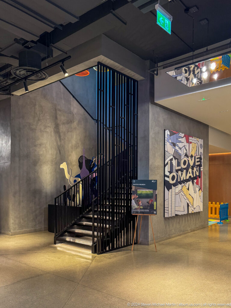 Black metal stair enclosure with wall artwork in Muscat, Oman.