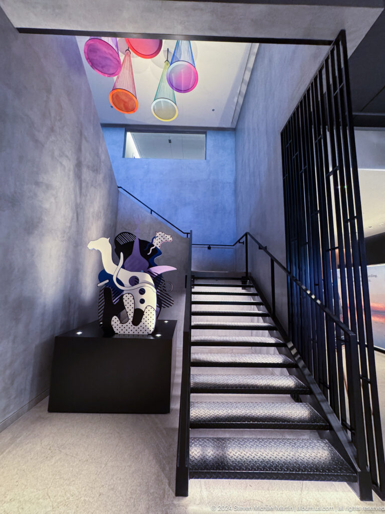 Cow-pattern sculpture beside black stair railing in Muscat, Oman.