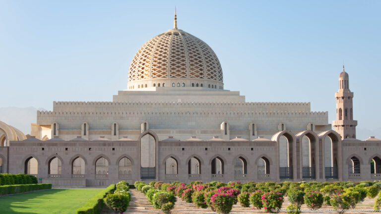 Grand mosque facade and central dome from lawn in Muscat, Oman.