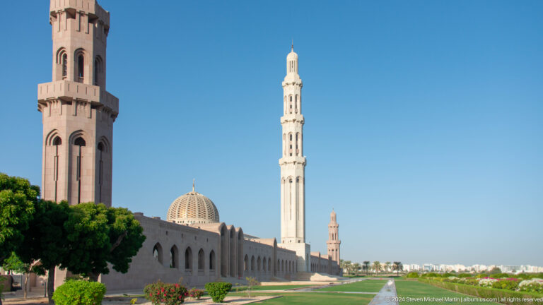 Wide view of mosque with dome and multiple minarets in Muscat, Oman.