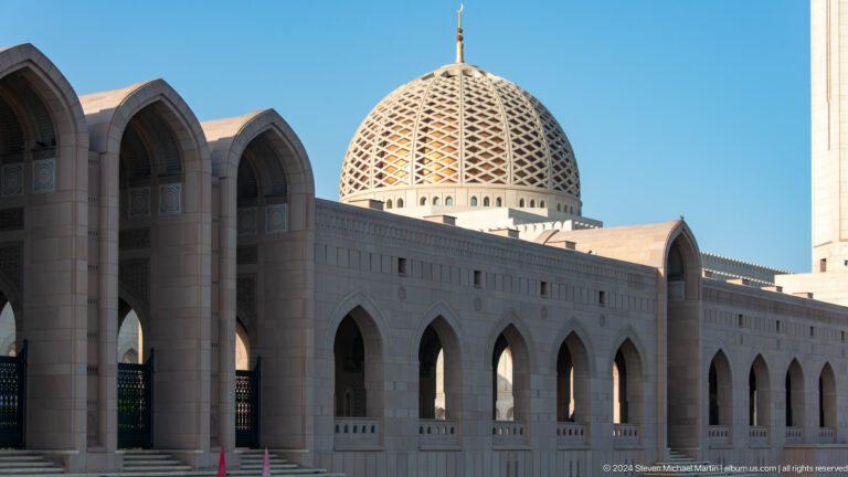 Arcade and patterned dome seen through arch in Muscat, Oman.