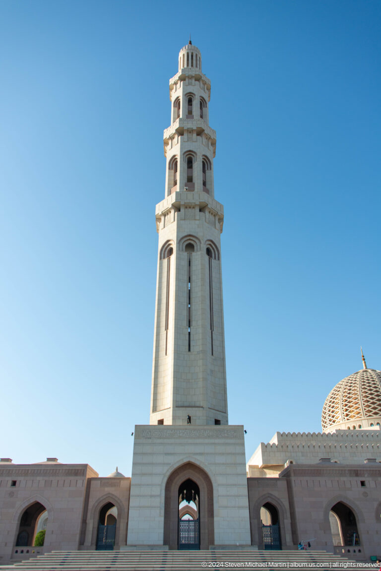 Upper minaret with balcony against blue sky in Muscat, Oman.