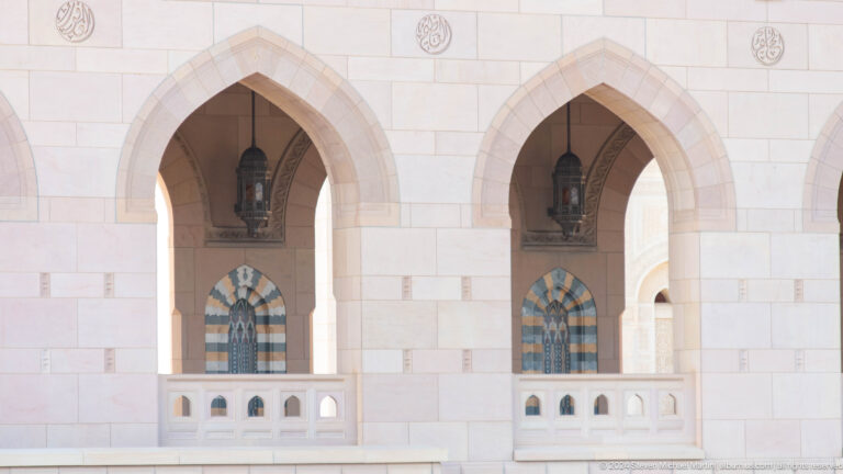 Paired pointed arches with patterned windows in Muscat, Oman.