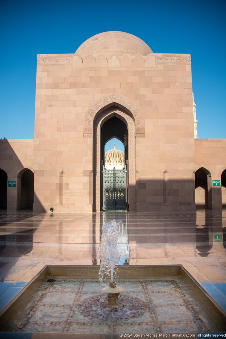 Monumental doorway reflecting mosque dome in Muscat, Oman.