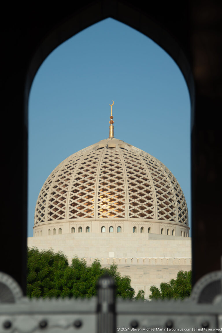 Dome seen through dark architectural opening in Muscat, Oman.