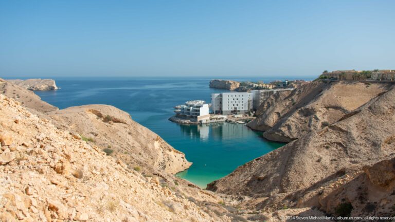 Turquoise bay enclosed by rocky headlands in Muscat, Oman.