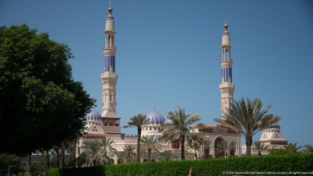 Mosque with twin minarets among palms in Muscat, Oman.