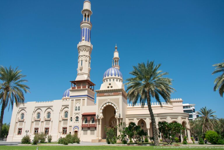 Ornate mosque with minaret and palms in Muscat, Oman.