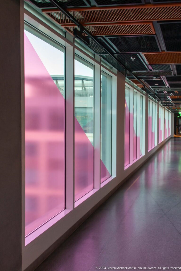 Corridor with translucent pink and blue window panels in Muscat, Oman.