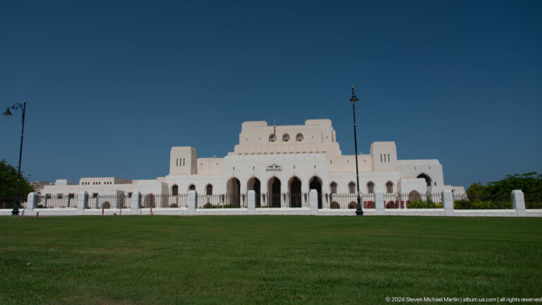 Large low white palace-like building across lawn in Muscat, Oman.