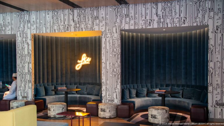 Dark lounge with glowing gold script sign in Muscat, Oman.