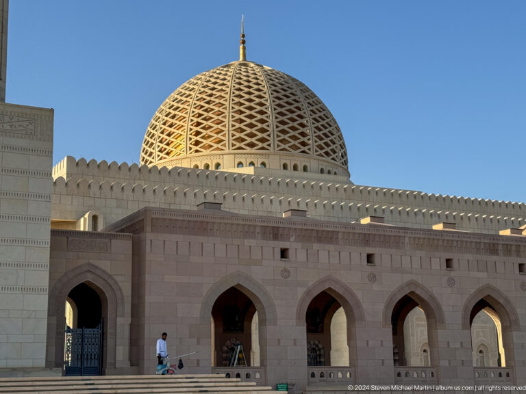 Mosque dome and arcade in warm sunlight in Muscat, Oman.