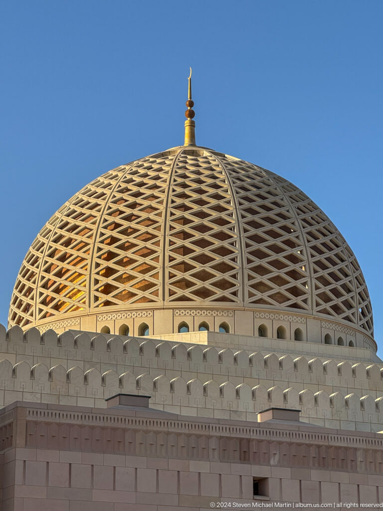 Golden lattice dome filling the frame in Muscat, Oman.