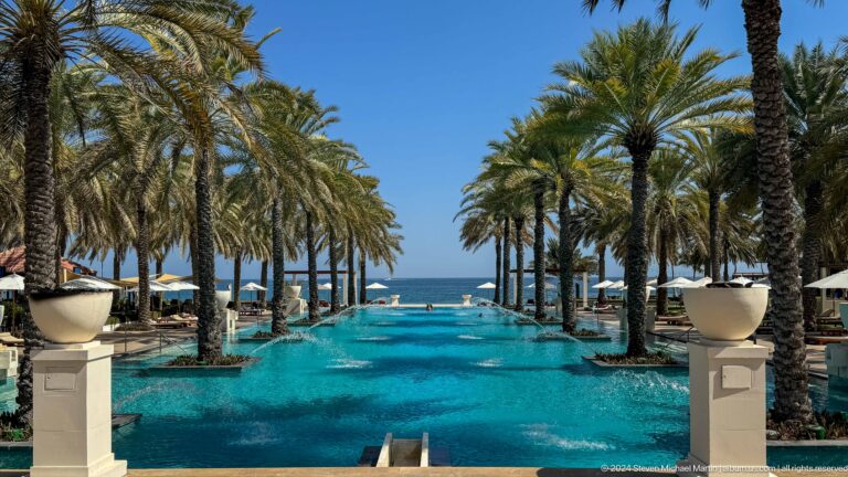 Resort pool lined with palms in Muscat, Oman.