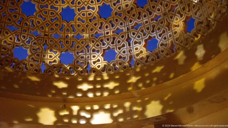 Ornate pierced metal canopy casting patterned shadows.
