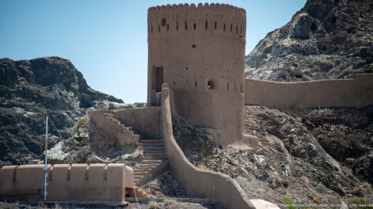 Close view of round watchtower and curtain wall.