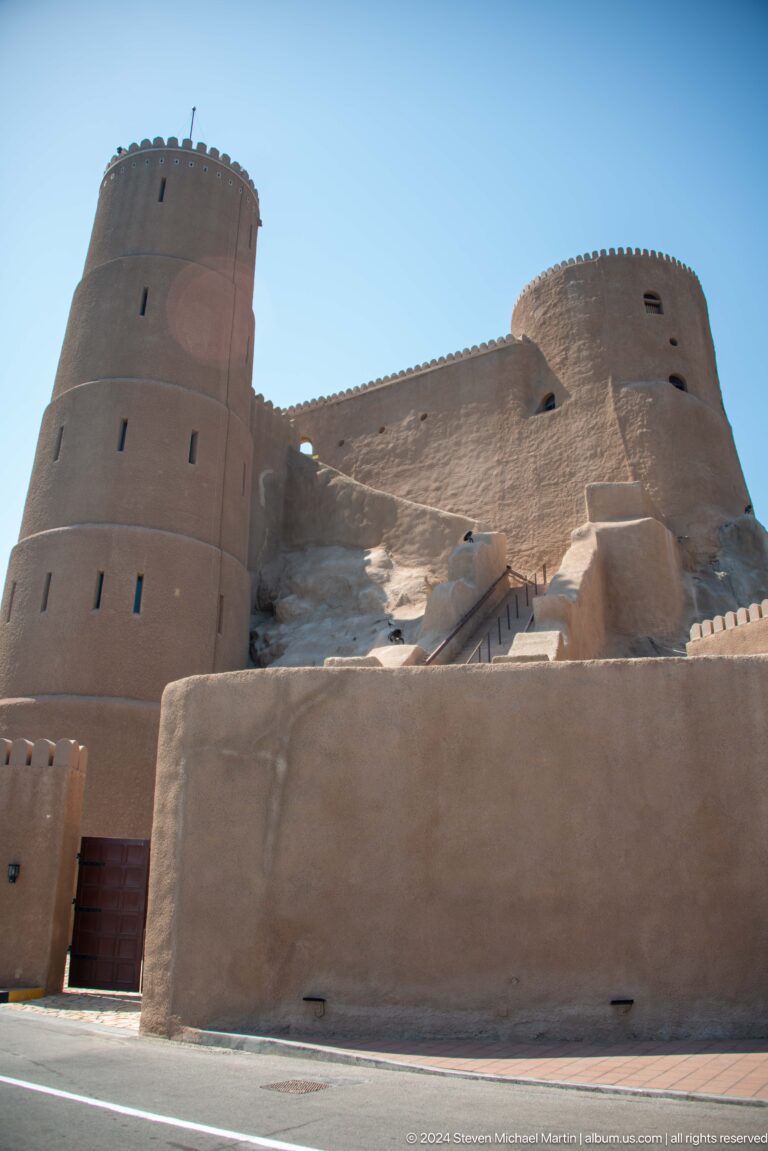 Massive sand-colored fort wall and bastion close-up.
