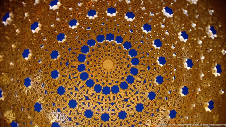 Circular geometric lattice pattern glowing blue and gold.