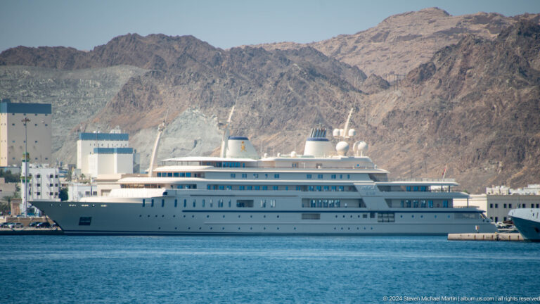 Large white cruise ship in harbor.