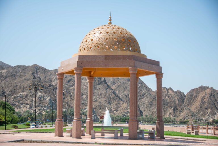 Ornate domed pavilion in landscaped park.