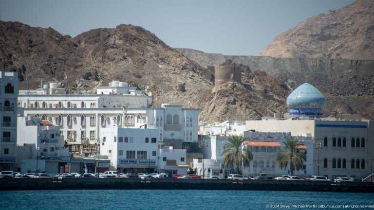 White waterfront buildings and blue mosque dome.