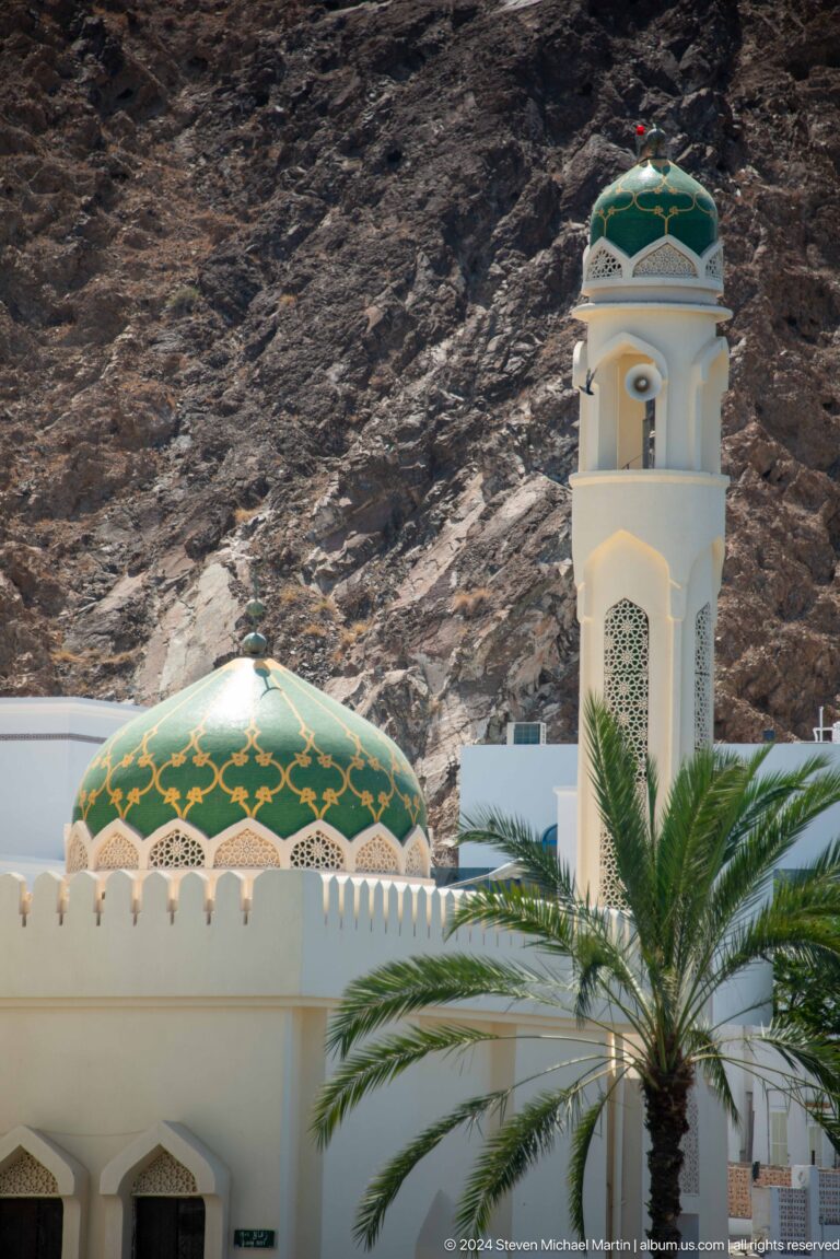 Green-patterned mosque dome and minaret.