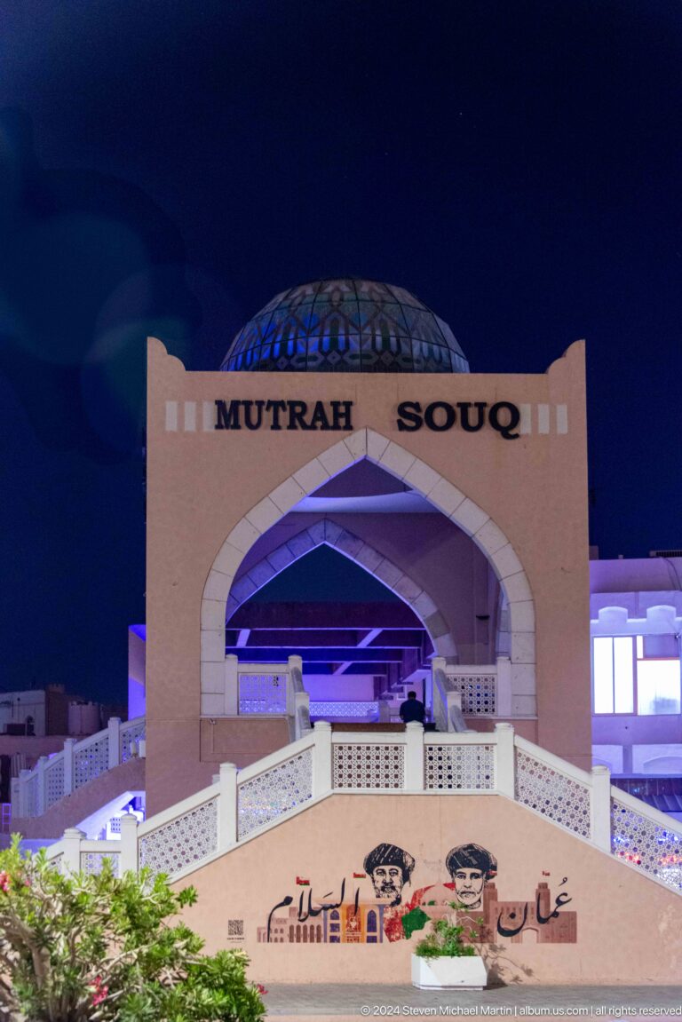 Mutrah souq entrance arch lit at night.