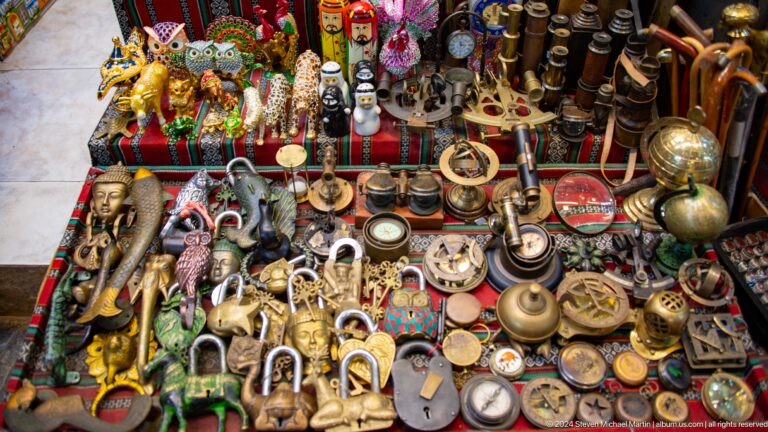 Table densely covered with brassware jewelry and trinkets.