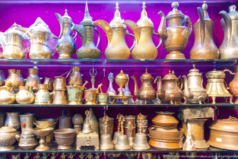 Rows of polished brass coffee pots and vessels.