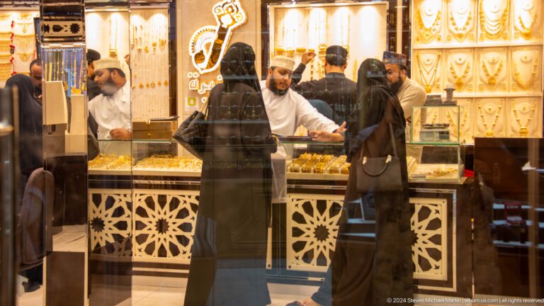 Customers at ornate jewelry or perfume counter.