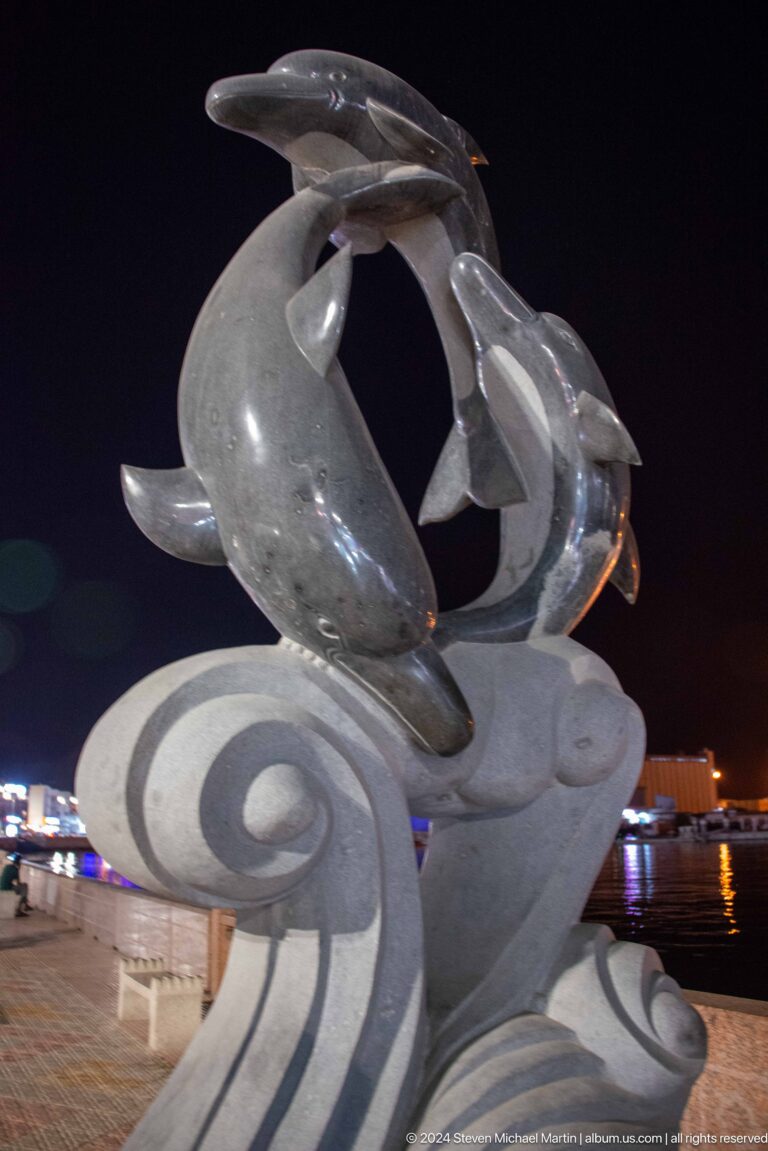 Close view of silver fish public sculpture.