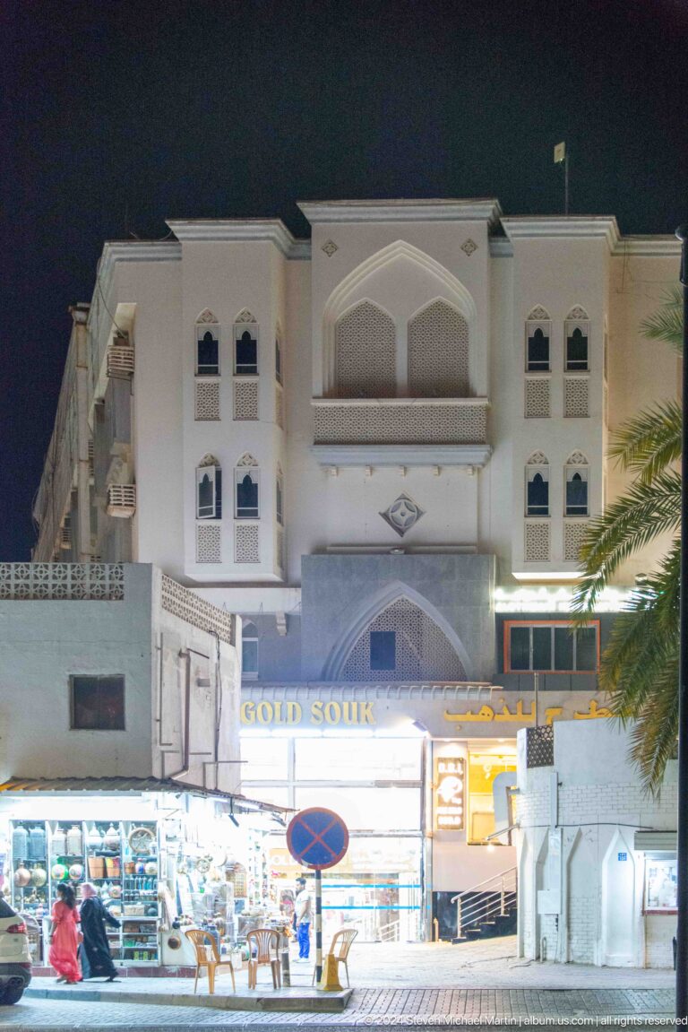 White hotel or commercial façade with arched windows.