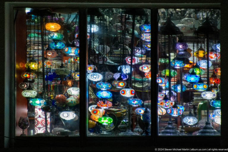 Shop window filled with colorful hanging lamps.