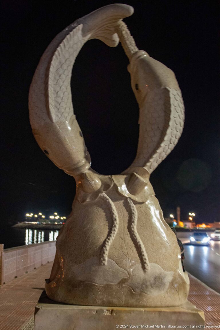Close view beneath large sculptural fish tails.