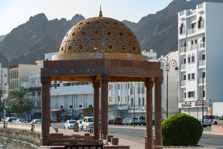 Domed open-sided pavilion beside waterfront.