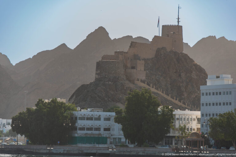 Fort complex silhouetted on mountain ridge.