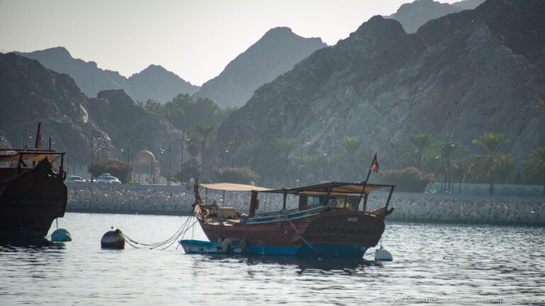 Small wooden dhow on calm water.