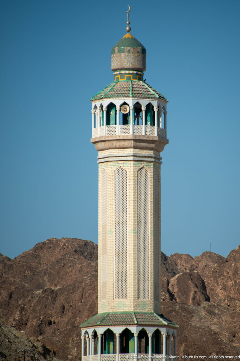 Plain minaret tower against blue sky.
