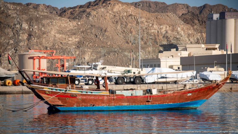 Painted wooden dhow moored in harbor.