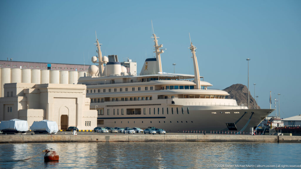 Large luxury yacht moored near port buildings.