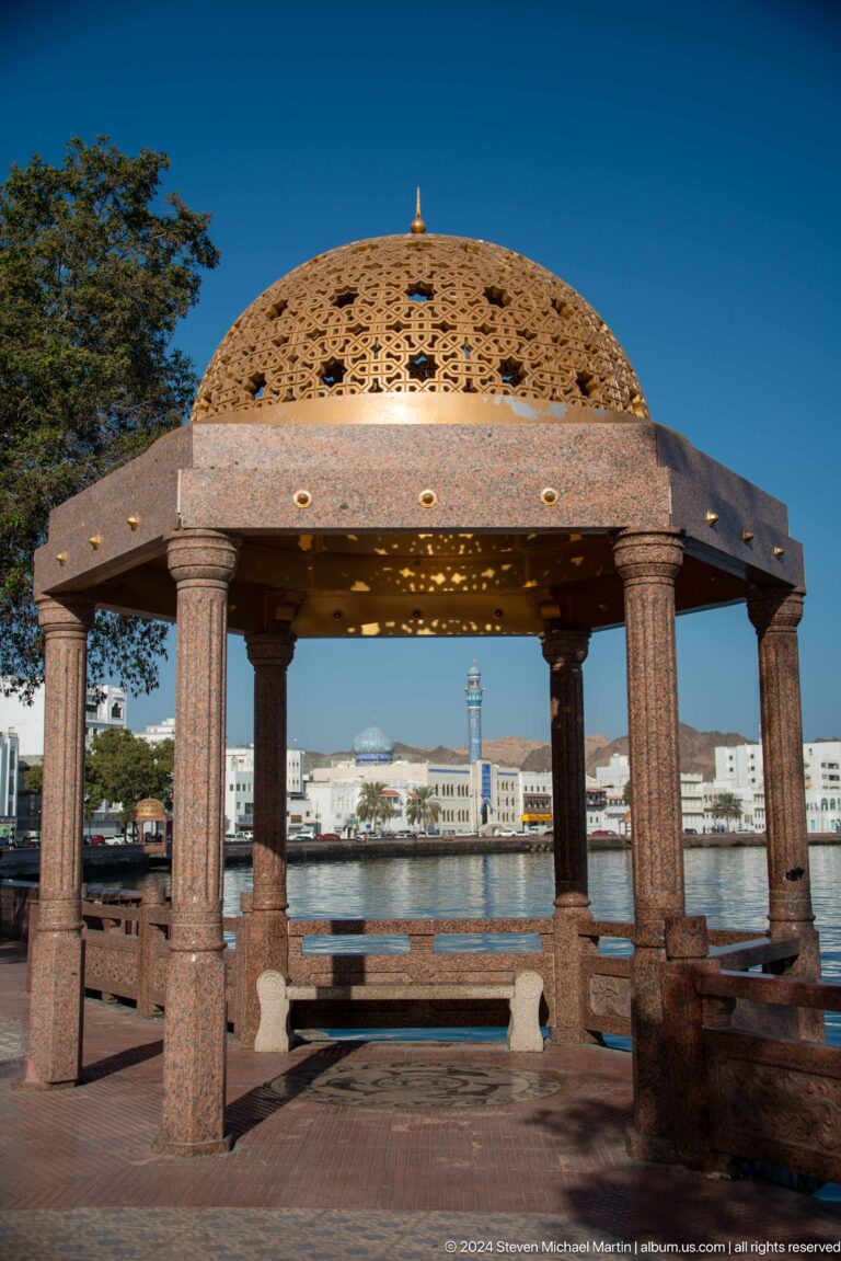 View through pavilion columns toward mosque and harbor.
