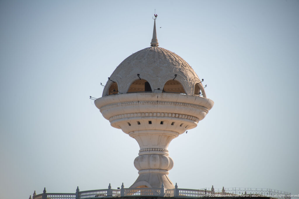 Large ornamental incense burner monument on hill.