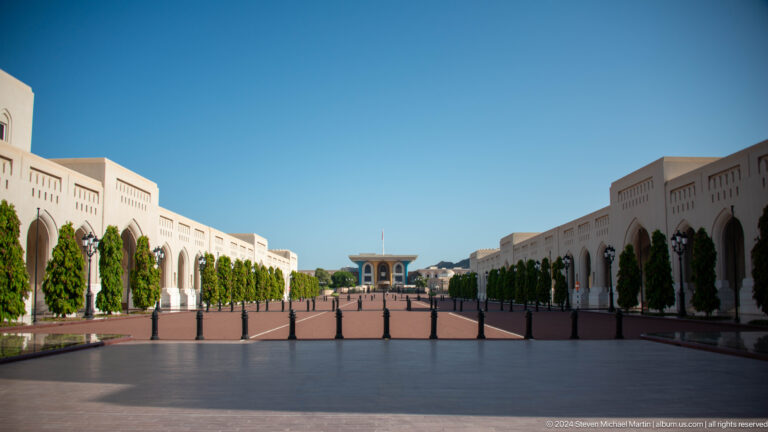 Broad ceremonial avenue flanked by white arcades.