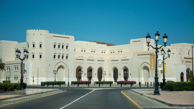 White institutional building on broad avenue.