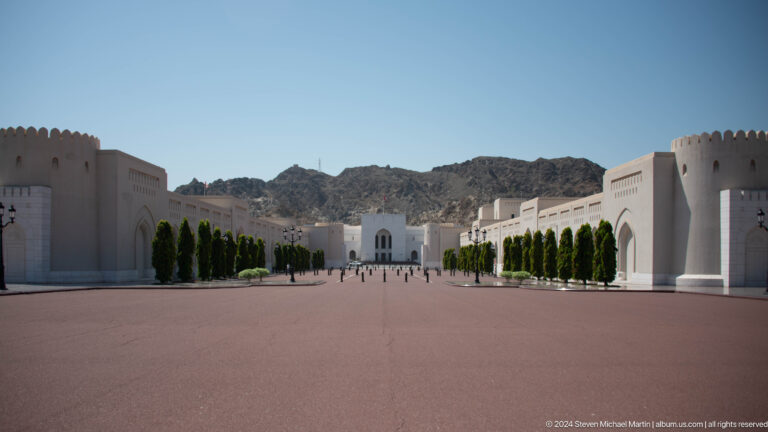 Wide empty ceremonial plaza framed by white buildings.