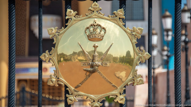 Large gold national emblem mounted on gate.