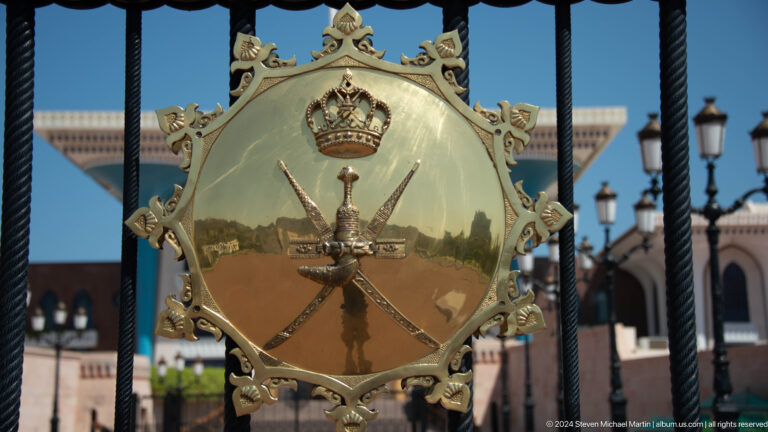 Close gold omani national emblem on gate.