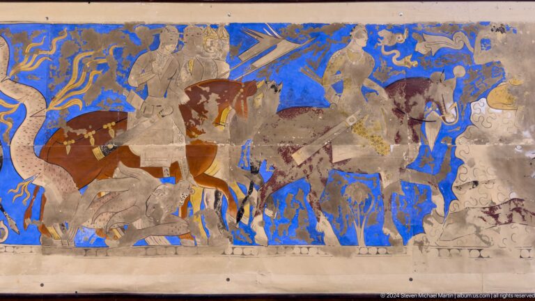 Fragmentary Sogdian wall painting from ancient Panjakent showing equestrian figures on a blue background painted on plaster.