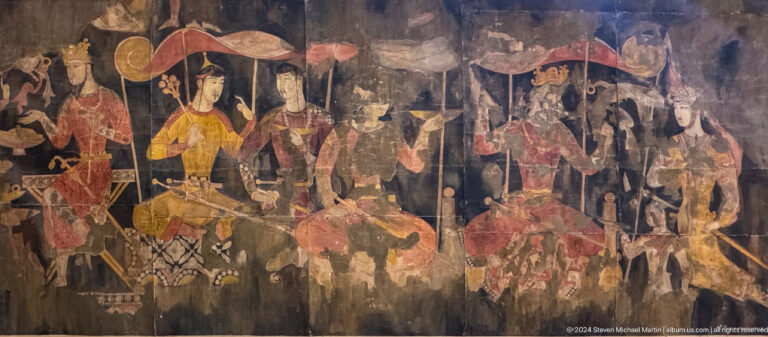 Sogdian wall painting from Ancient Panjakent showing several richly dressed seated figures grouped in a dark, interior-like setting, suggesting an elite courtly or banquet scene.